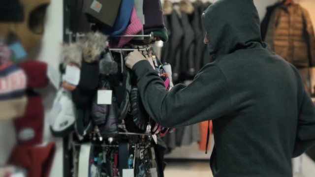 Thief in shop, shopping gangster, man hiding clothes at store
