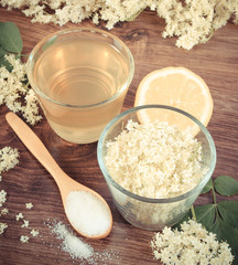 Vintage photo, Flowers and juice of elderberry, ingredients for preparing beverage on rustic board
