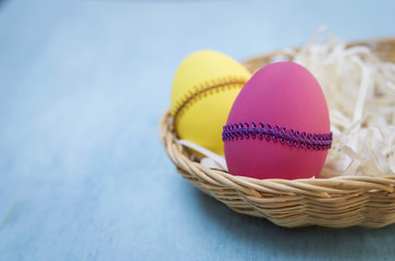 Design Easter egg in rattan basket with space on blue background