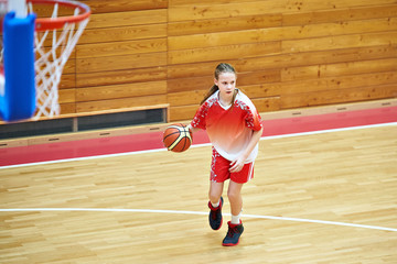 Girl in sport uniform playing basketball