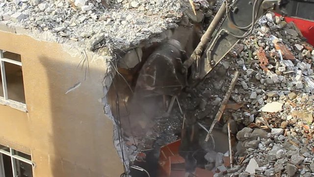 Building under deconstruction with excavator. Digger using its bucket to demolish house. Demolition of the building. Time Lapse