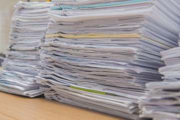 documents on desk stack up high waiting to be managed