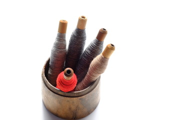 小さな入れ物に入った大管。
縦糸を巻いた大管。