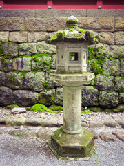 Fototapeta na wymiar Japanese style stone lantern at the stone wall, Nikko, Japan