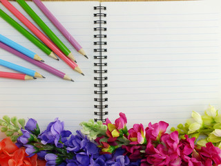 notebook pencil and flowers on a white background
