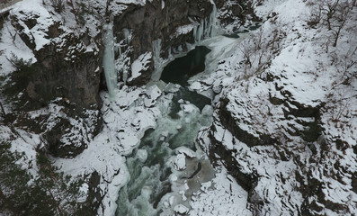 Winter landscape. River flowing in granite canyon.