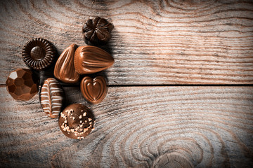 Assorted chocolate candies on a wooden background