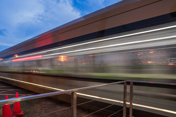 Naklejka premium Blurred view of train leaving platform in city of China.