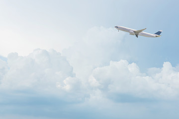 Kommerzielle Flugzeugabfahrt vom Flughafen, der über strahlend blauen Himmel und weiße Wolken am Himmel fliegt