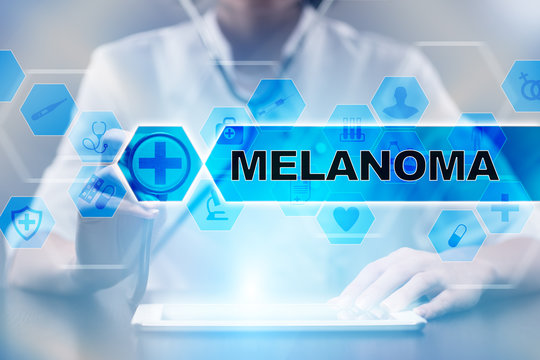 Medical doctor using tablet PC with melanoma medical concept.