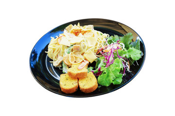 carbonara spaghetti with garlic bread and salad on black plate isolated on white