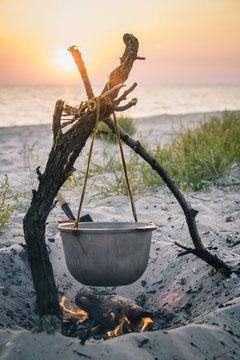Photo of cauldron with food on seaside