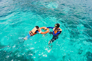 Father and son swimming in the sea.