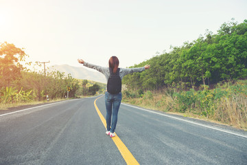 Fototapeta premium young women happy walking on the road at mounthain and sunet