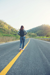 young women happy walking on the road at mounthain and sunet