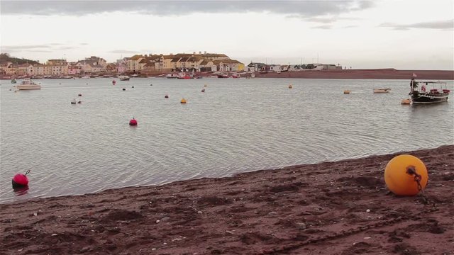 Gentle Sea Waves Lap Buoys and Sand of Shaldon Beach - view of Teignmouth Harbor