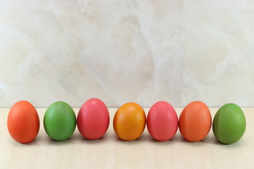 Row of colorful easter eggs on marble with copy space background.