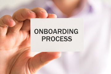 Businessman holding a card with ONBOARDING PROCESS message