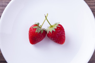 Sweet strawberries in the white dish. Bright image by studio light
