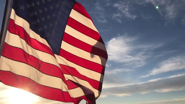 American flag flying in the wind at sunrise slow motion