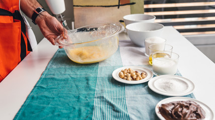 Man preparing a homemade cake with chocolate and hazelnuts