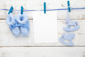 Greeting children form with blue booties and wooden horse. Flat lay