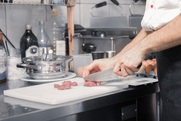 chef closeup knife cutting meat