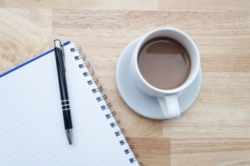 coffee with notebook on wooden table, view from above