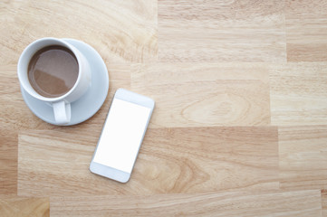 coffee and smartphone on wooden table and copy space, soft focus