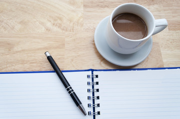 coffee with notebook on wooden table, view from above