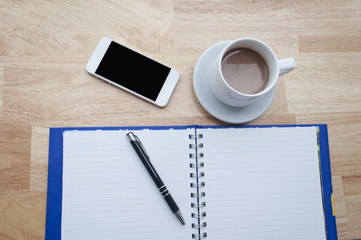 coffee with notebook,smartphone on wooden table, view from above