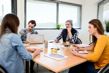 group of young cool hipster creative business people in casual wear working together in meeting room of a startup company
