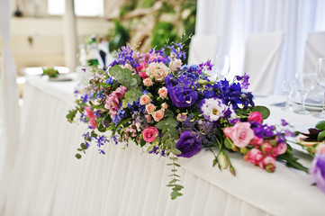 Violet and purple flowers at awesome wedding table.