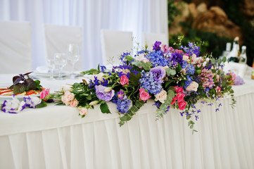 Violet and purple flowers at awesome wedding table.