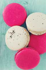 raspberry and vanilla macaroons on turquoise wooden surface