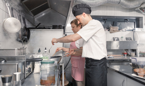 two people cooking, commercial kitchen