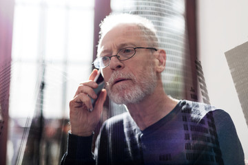 Senior businessman talking on phone, double exposure