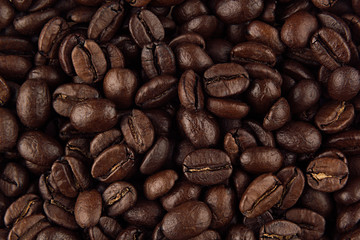 Roasted coffee beans closeup top view as background.