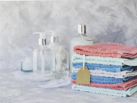 Towel stack with price tag on a white marble background, space for text, selective focus