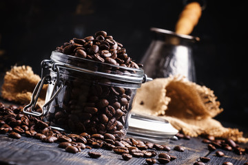 Coffee beans in a glass jar, black background, selective focus
