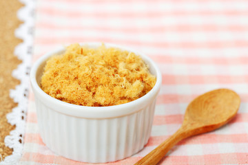 dried pork floss in white cup with wooden spoon