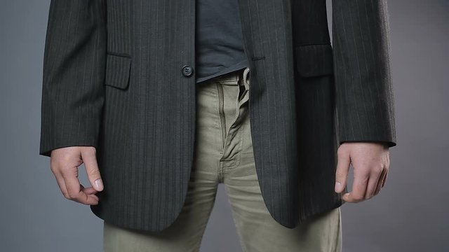 Slim man zipping and unzipping pants zipper, man's clothes, close-up shot