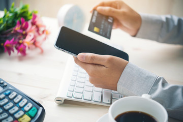 Online payment,hand using phone on worktable