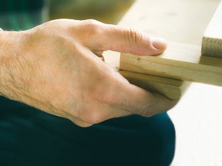 Man crafting wooden chair object keeping wooden boards in hands. Do it yourself project making process closeup