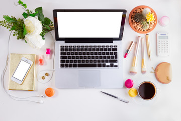 Feminine workspace border with notebbok coffee and flowers, top view and copy space on empty screen