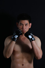 Fototapeta na wymiar asian Fighter boxer standing strong on black background
