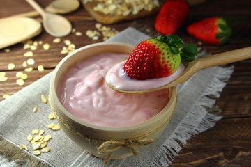 домашний йогурт со свежей клубникой в деревянной миске