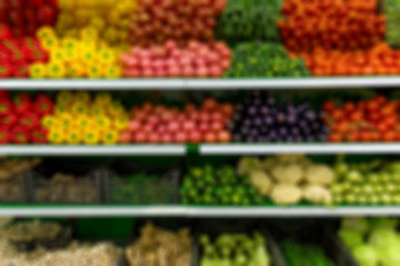 Fresh organic Vegetables and fruits on shelf in supermarket, farmers market. Abstract blurred supermarket aisle with colorful shelves and unrecognizable customers as background