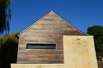 Façade en clin et pierre naturelle.