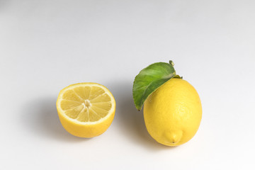 Whole lemon and half lemon on a white background
